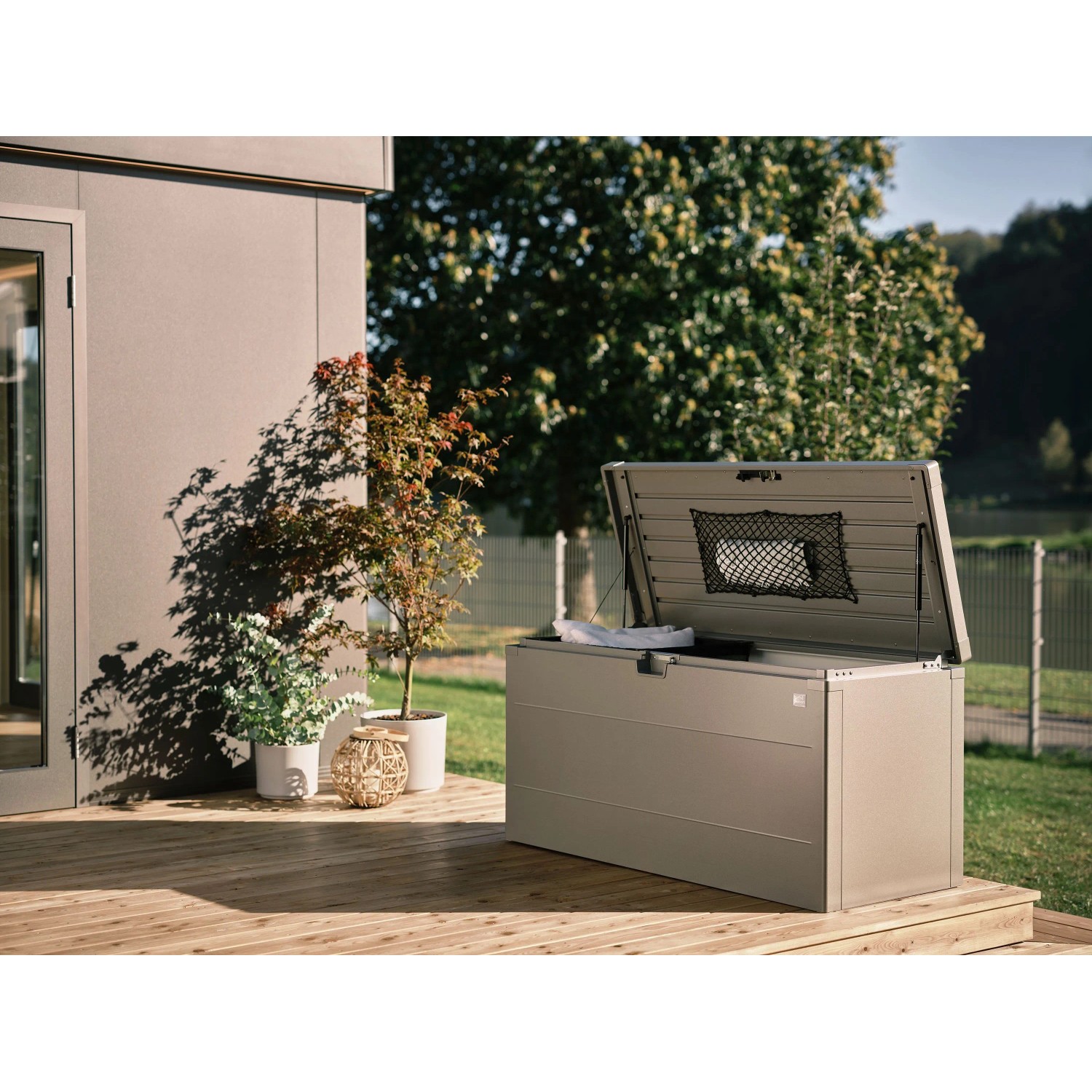 Biohort StyleBox 140 grigio quarzo metallizzato, coperchio aperto con molla a gas, su terrazza in legno. Box universale impermeabile.