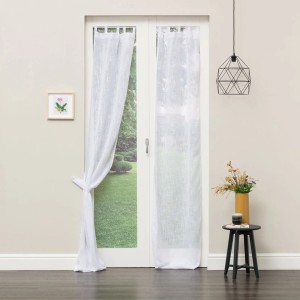 Tenda in tessuto t.b.t. chiara e trasparente davanti a una porta finestra.