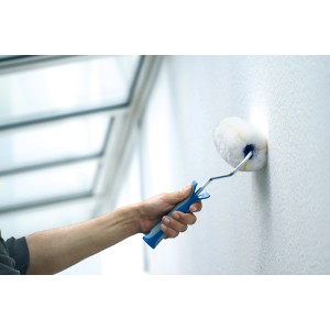 Mano che dipinge la parete con rullo LUX Goldfaden (25 cm) con impugnatura morbida 2K imbottita.