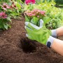 Guanti da giardino verde-grigi taglia 8 mentre piantano un fiore in un'aiuola.