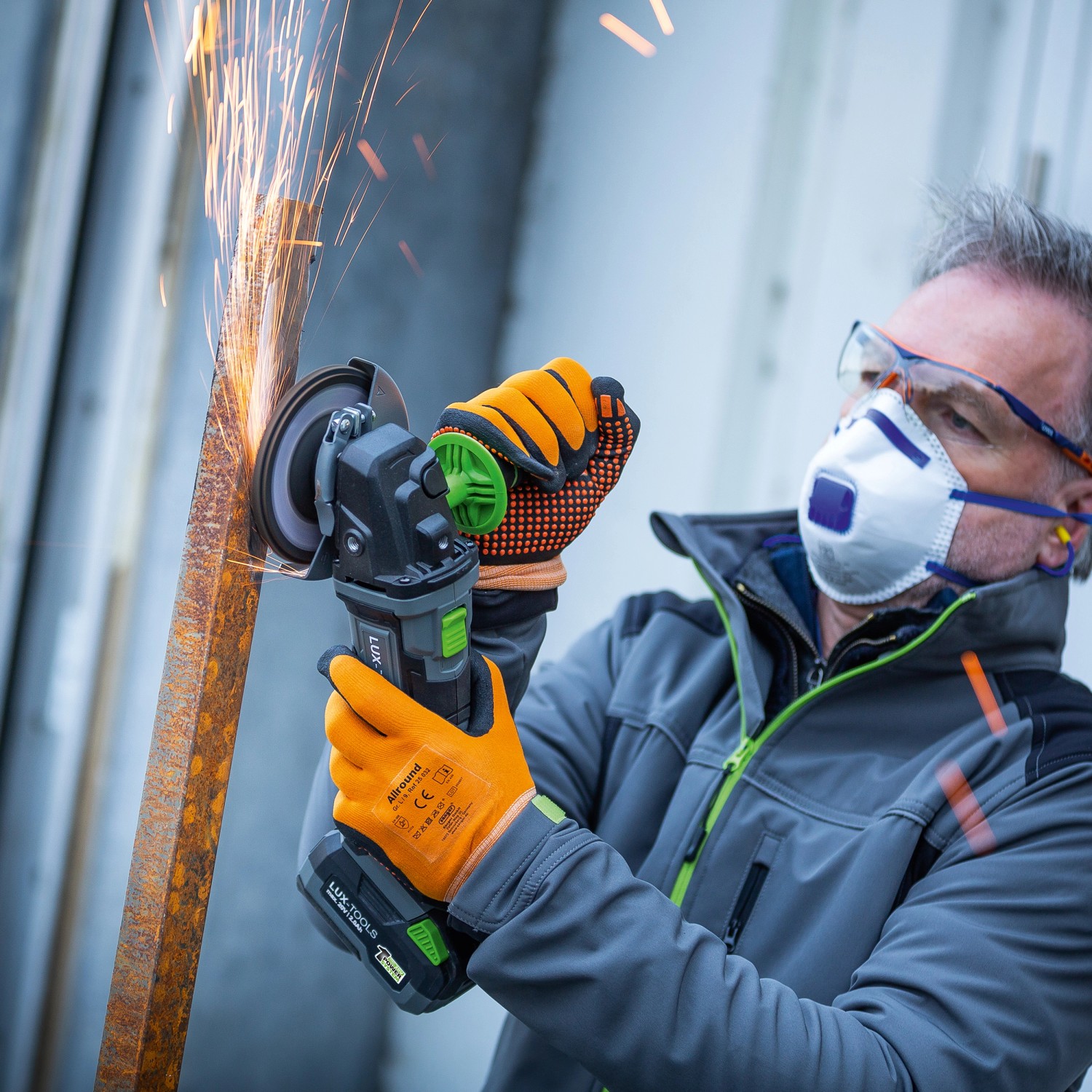 Smerigliatrice angolare a batteria LUX A-WS-20/115 che produce scintille durante la smerigliatura del metallo.