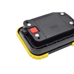 t.b.t. Faro LED da cantiere, vista posteriore con vano batteria e pulsante di accensione rosso.