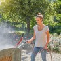 Donna pulisce carriola con Gardena Comfort Cleaning Sprayer ecoPulse™ in giardino.