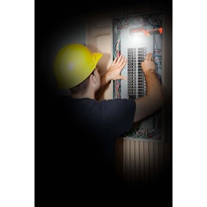 Elettricista controlla una scatola fusibili con un tester di tensione. Impianto elettrico in casa.