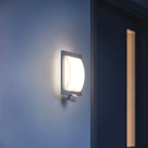Lampada da parete per esterni Steinel L 20 S color antracite con rilevatore di movimento su una parete di casa.