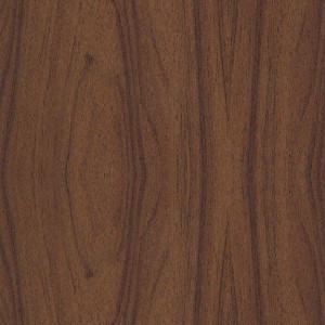 Primo piano di una pellicola adesiva con design in legno di noce scuro.