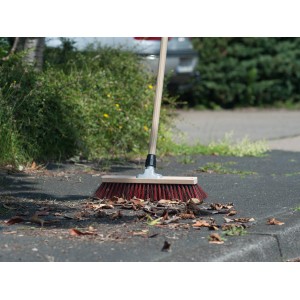 Testa di scopa LUX Besenkopf Südharzer 60 cm con manico in legno che spazza le foglie sull'asfalto.