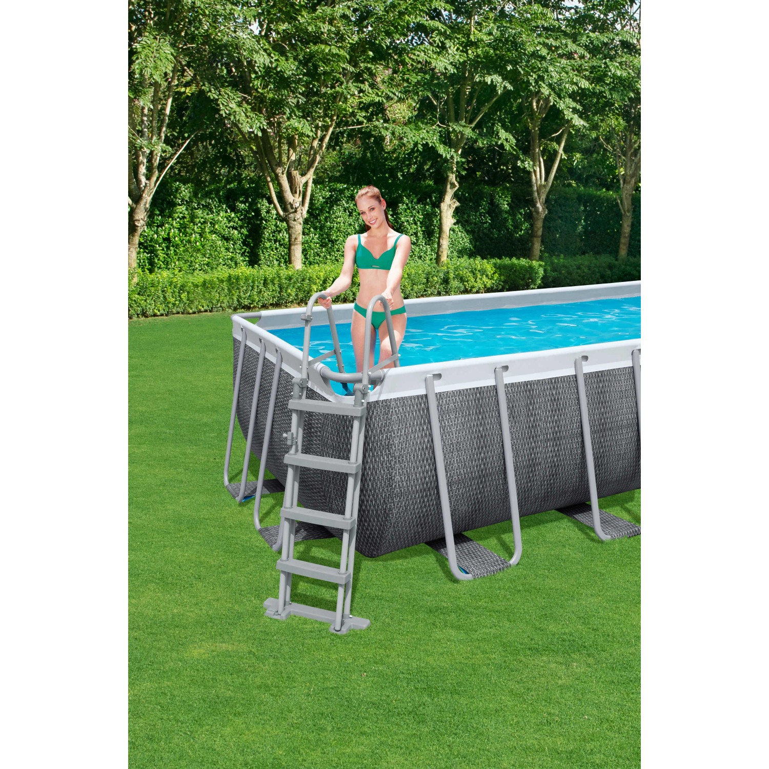 Piscina fuori terra rigida rettangolare t.b.t. con scaletta in giardino, donna entra in acqua.