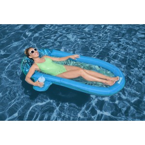 Donna si rilassa su lounge piscina t.b.t. blu in acqua.