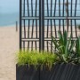 t.b.t. fioriera da esterno con grigliato e piante, sfondo spiaggia.