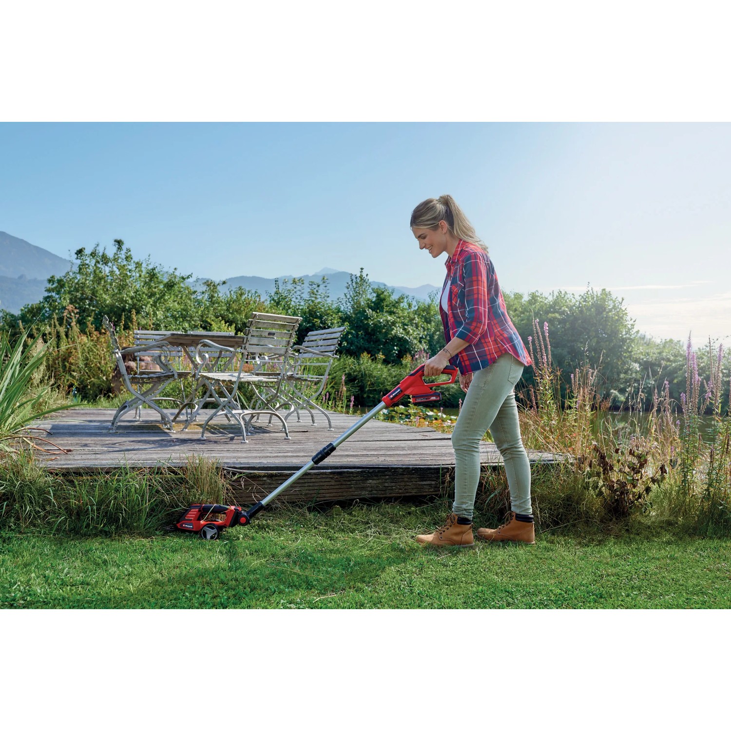 Tagliasiepi a batteria Einhell Power X-Change GE-CG 18/100 Li T-Solo in uso per la rifinitura dei bordi del prato.