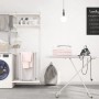 Lavanderia con lavatrice, scaffali, asse da stiro e biancheria. Idee di arredamento pratiche.