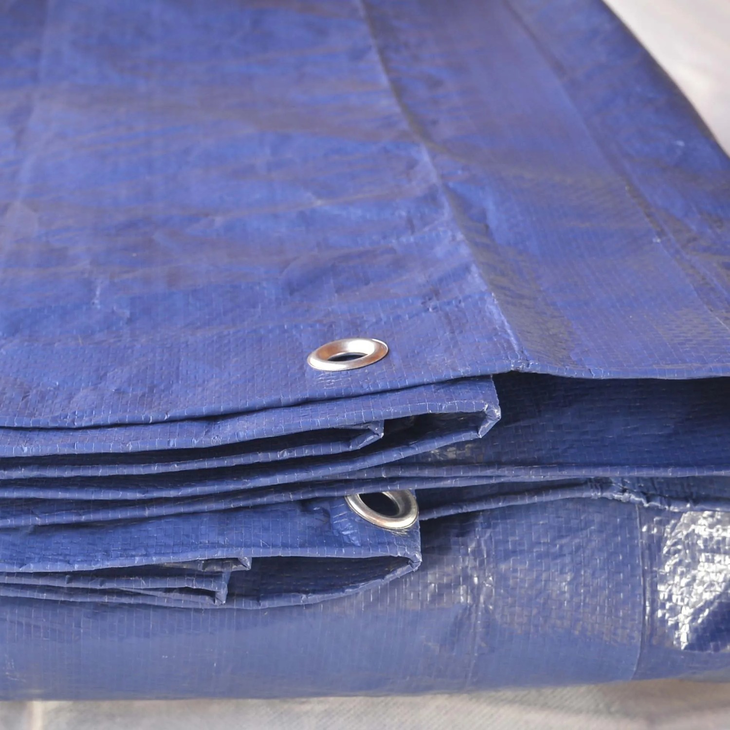 Telone di copertura blu con occhielli, ideale per la protezione dagli agenti atmosferici.