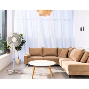 Ventilatore a piantana bianco in soggiorno. Il ventilatore fornisce aria fresca.