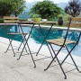 Set mobili da balcone: tavolo pieghevole e due sedie pieghevoli in legno e metallo a bordo piscina.