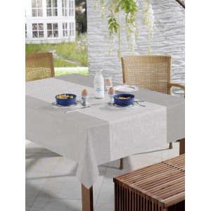 Tavolo con tovaglia grigia t.b.t. in giardino, decorato con stoviglie e cibo.