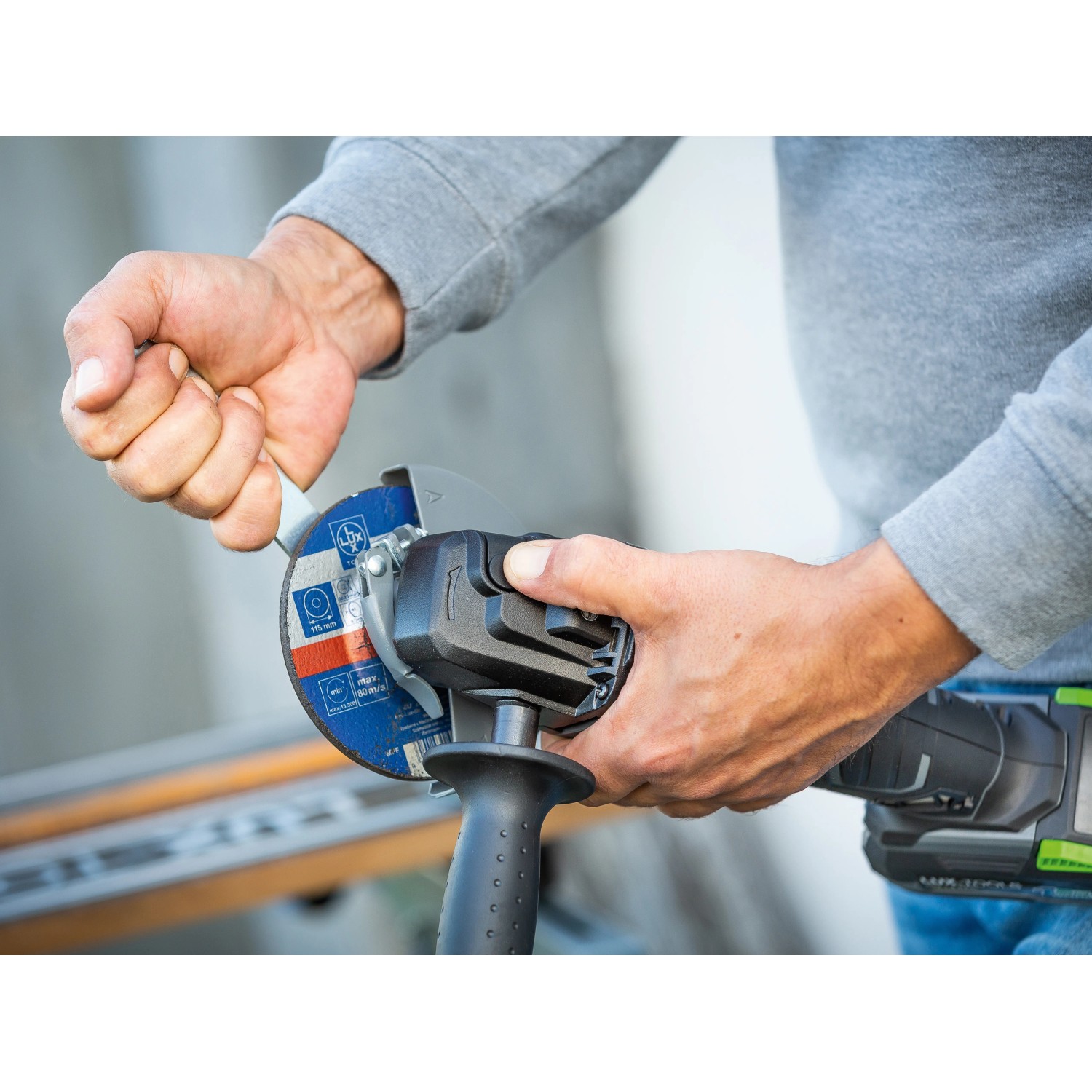 Smerigliatrice angolare a batteria LUX A-WS-20/115 in uso durante la sostituzione del disco abrasivo.