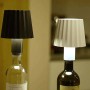 Luci decorative da esterni t.b.t. in bianco e nero su bottiglie di vino.