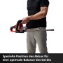 Tagliasiepi a batteria Einhell GE-CH 18/60 Li-Solo in uso, rosso/nero. Tagliasiepi senza fili.