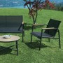 Set di mobili da giardino t.b.t. con panca, poltrona e tavolo su prato.