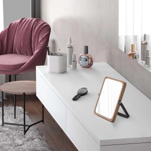 Tavolo con specchio da trucco, spazzola e prodotti cosmetici. Specchio da trucco per l'uso quotidiano.