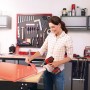 Donna rimuove pellicola con pistola ad aria calda a batteria Einhell TE-HA 18 Li Solo in officina.