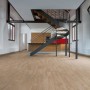 Pavimento laminato chiaro in una stanza con scala a chiocciola. Il laminato crea un'atmosfera calda.