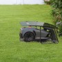 Robot tagliaerba t.b.t. grigio con stazione di ricarica su prato.
