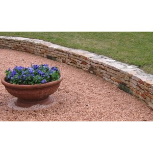 Area terrazzata con ciottoli e granuli t.b.t., delimitata da un muro in pietra.