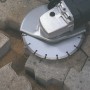 Disco diamantato da 115 mm in uso con smerigliatrice angolare per tagliare pavimentazione.