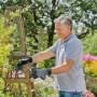 Uomo pota rose con cesoie da giardino Gardena Assistcut. Cesoie a batteria per utensili da giardino.