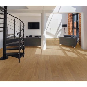 Pavimento vinilico chiaro in soggiorno con scala a chiocciola e mobili grigi.