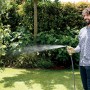 Uomo che irriga il giardino con lancia/pistola per irrigazione t.b.t.