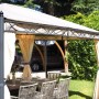 Dettaglio di un gazebo con tende e set da tavolo da pranzo in giardino.
