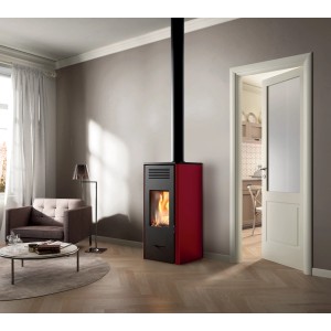 Stufa a legna rossa t.b.t. in soggiorno con poltrona e porta.