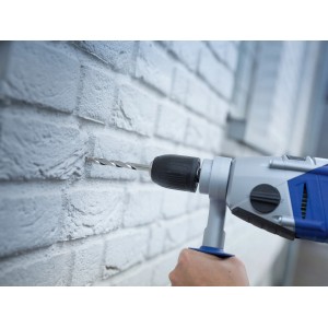 Punta per muro LUX che fora un muro di mattoni con trapano a percussione.