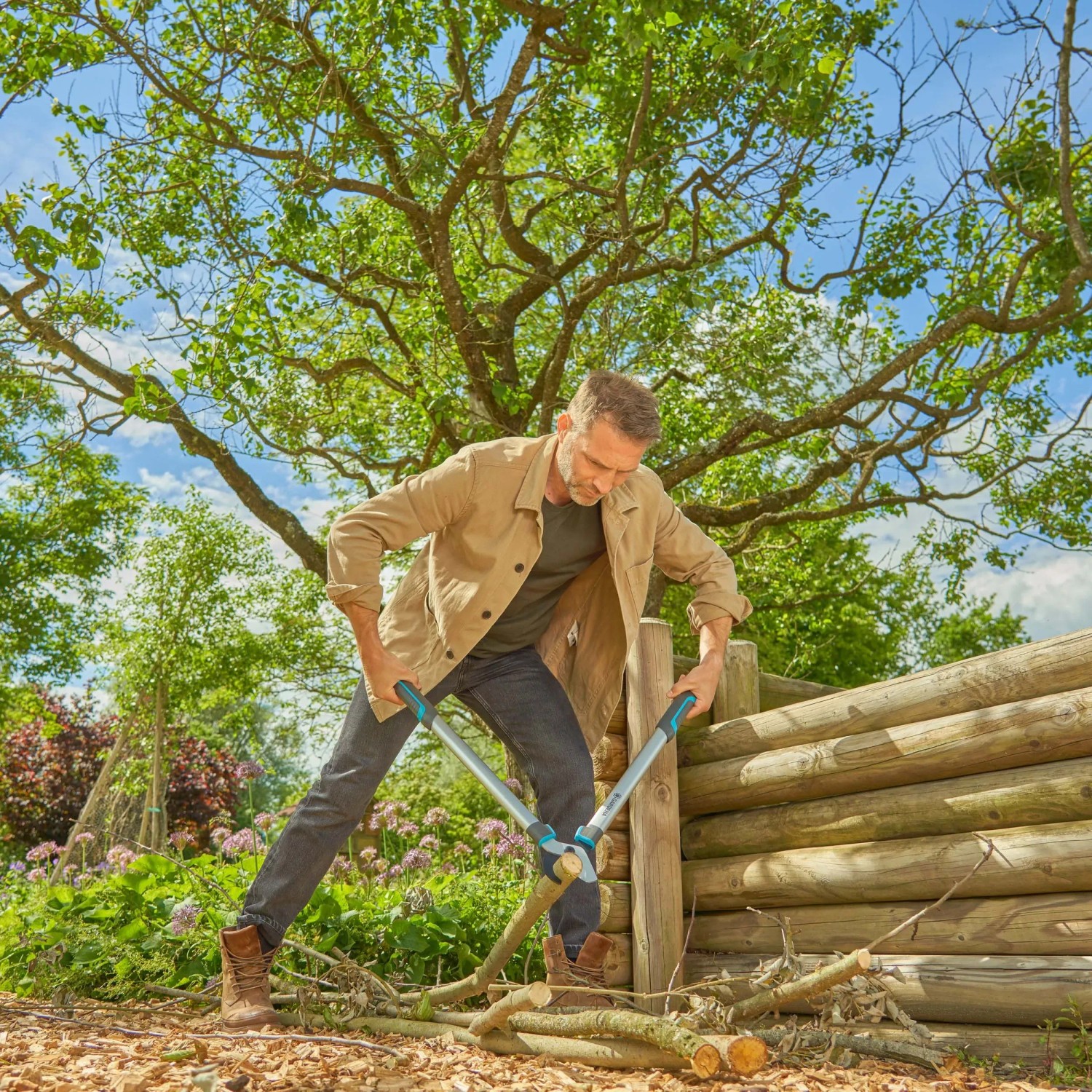 Uomo taglia rami con cesoie Gardena EasyCut L in giardino.