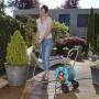 Donna che annaffia la pianta con il set avvolgitubo Gardena CleverRoll S (tubo da 20 m, accessori).