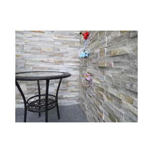 Rivestimento murale in pietra naturale t.b.t. con tavolo e decorazioni.
