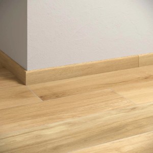 Piastrelle per pavimenti chiare effetto legno con battiscopa coordinato.