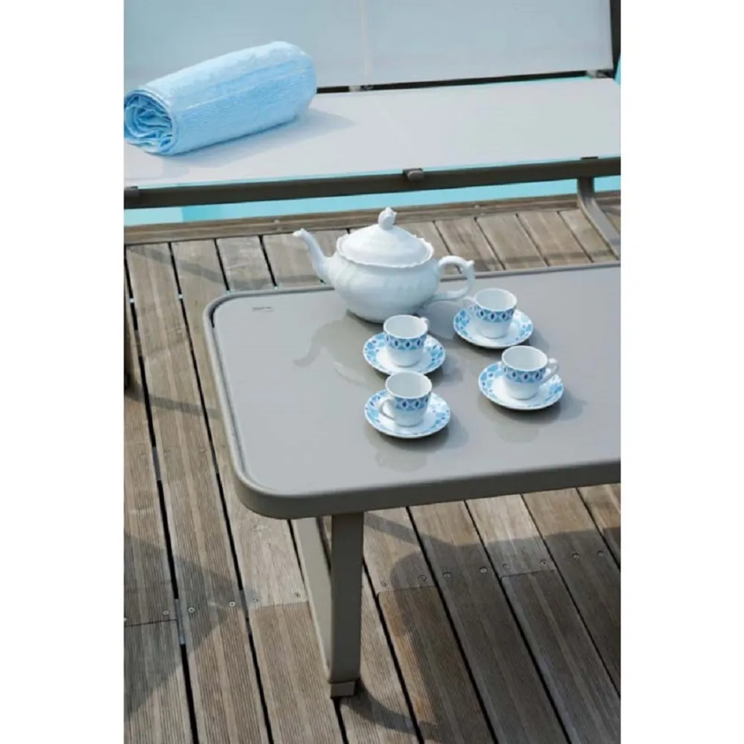 Tavolo con teiera e tazze, parte di un set di mobili da giardino.