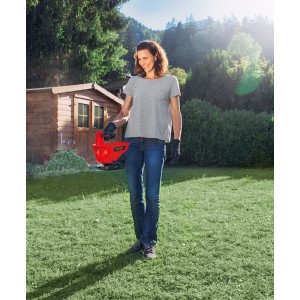 Donna utilizza spargitore Einhell Power X-Change GE-US 18 Li in giardino.