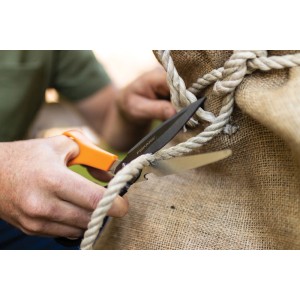 Persona che taglia la corda con le forbici t.b.t.. Attrezzo da taglio.