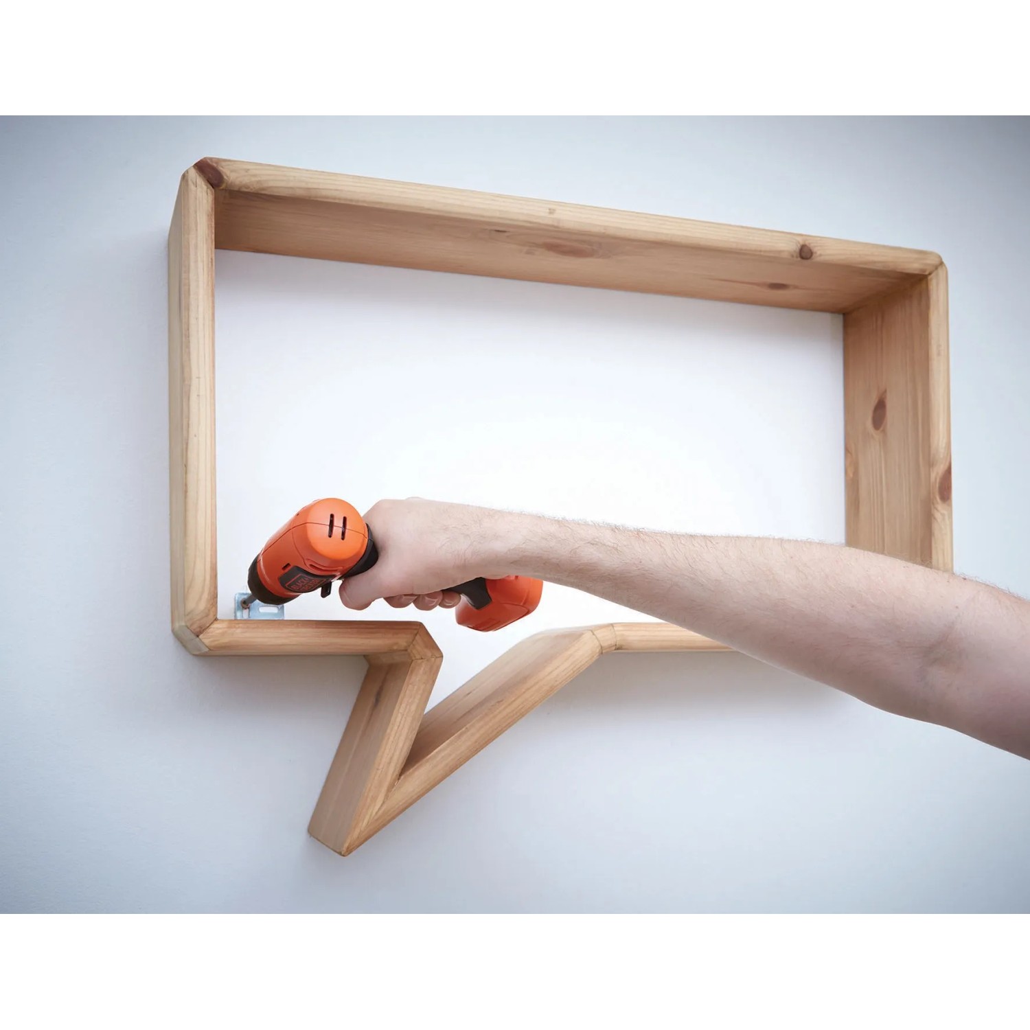Avvitatore a batteria Black+Decker BDCD8 avvita una mensola di legno.