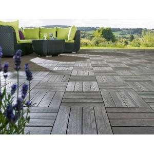Piastrelle a click WPC color antracite effetto legno posate su una terrazza con mobili da giardino.