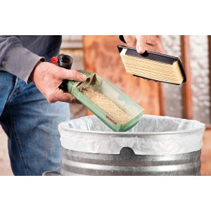 Svuotamento del contenitore della polvere della levigatrice a nastro Bosch PBS 75 A sopra un bidone della spazzatura.