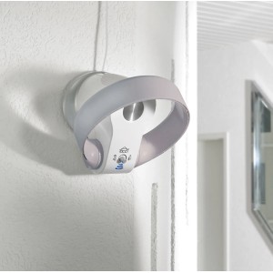 Termoventilatore elettrico t.b.t. bianco e rotondo montato a parete in un bagno moderno.