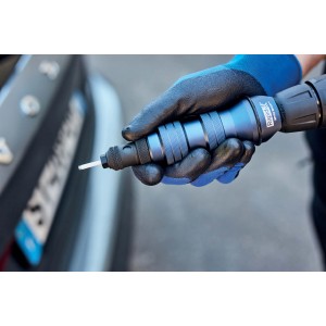 Mano con pinzetta Rapid blu davanti all'auto. Strumento per lavori di precisione.