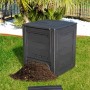 Compostiera t.b.t. nera con mucchio di compost nel giardino.