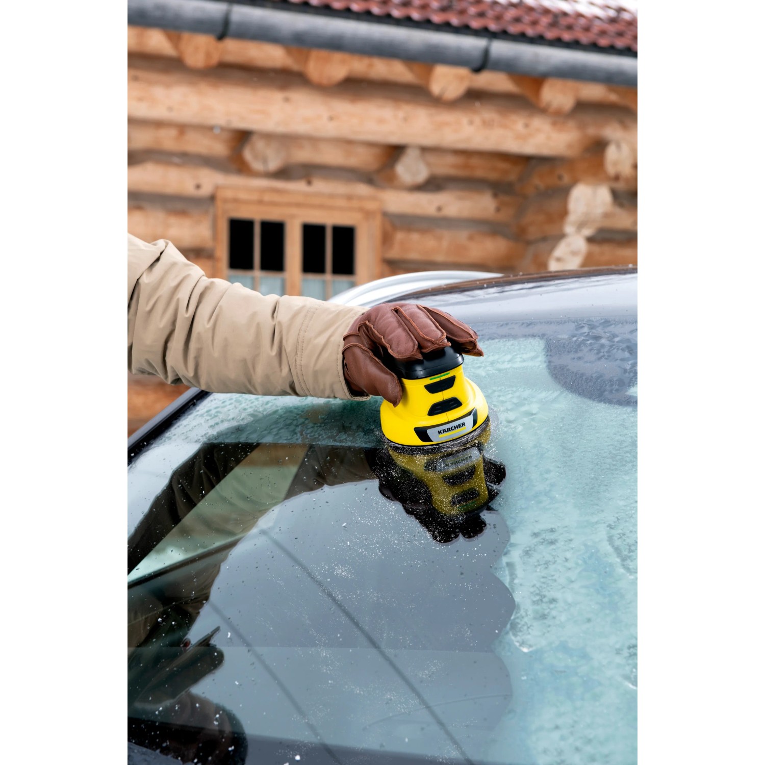 Raschiaghiaccio elettrico Kärcher EDI 4 giallo in uso su un parabrezza auto ghiacciato.